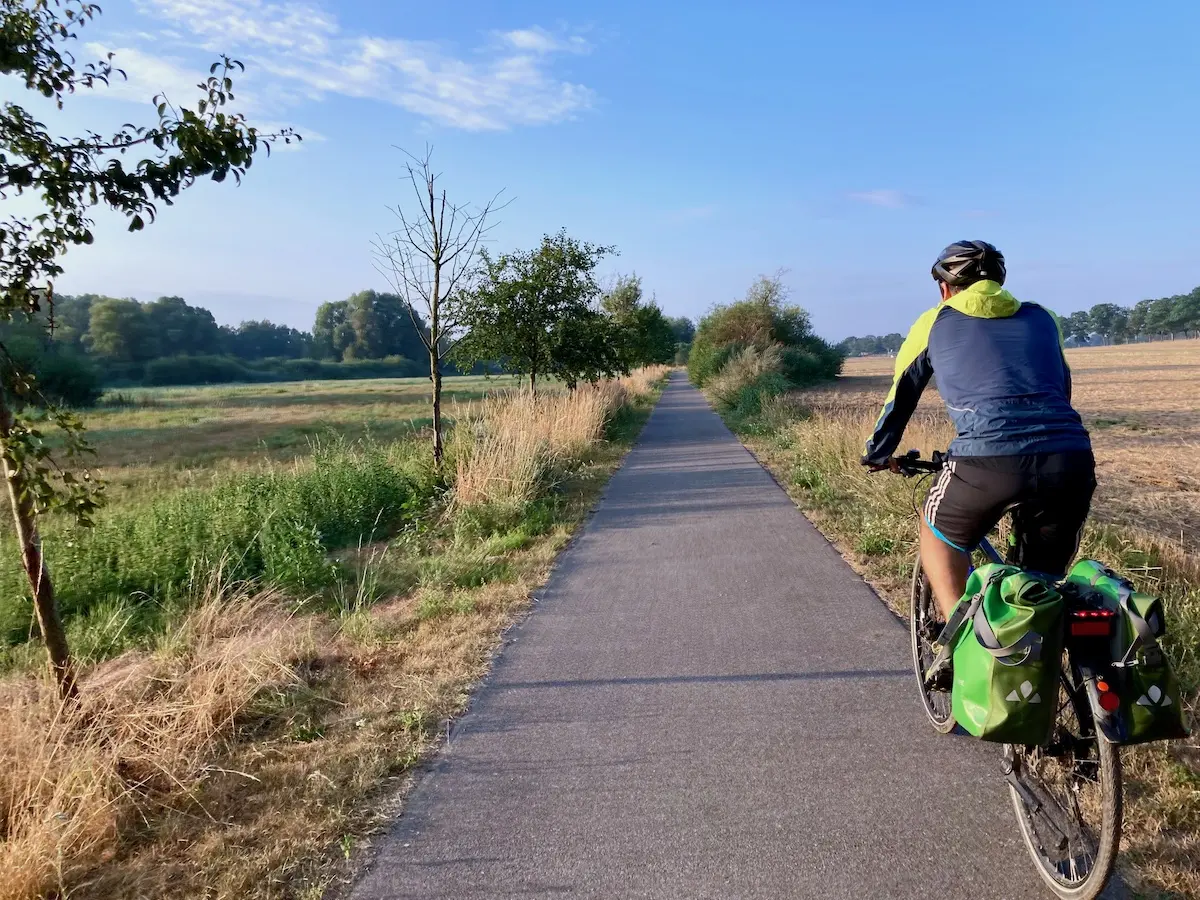 Ein Fahrrad fahrendes CPC-Mitglied auf einem ländlichen Radweg von hinten